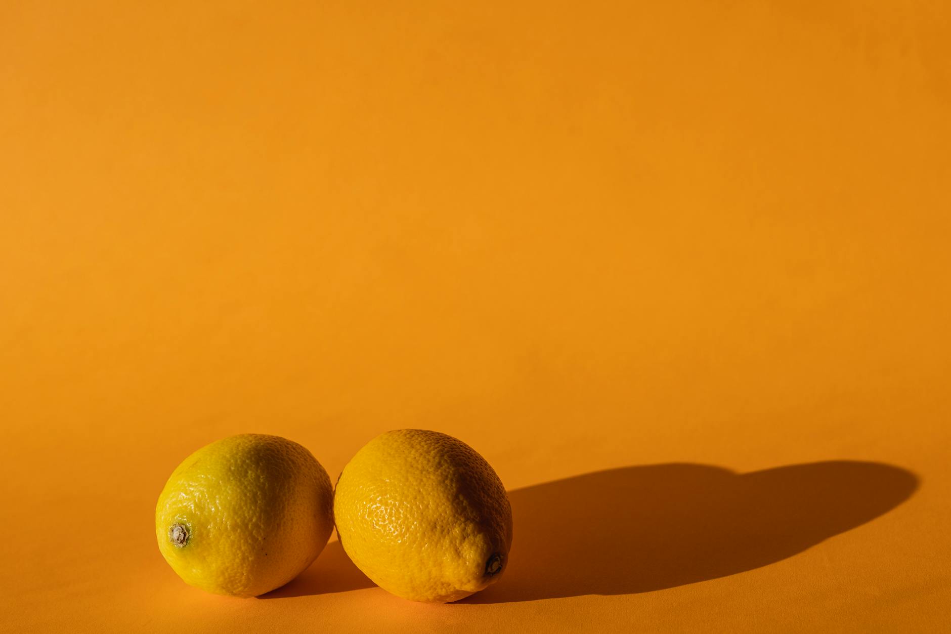 Ripe vivid lemons composed on yellow background, symbolizing fresh starts and healing